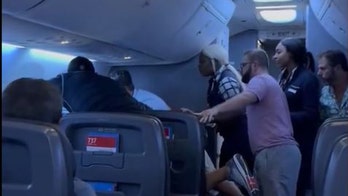 Los pasajeros intervienen en un vuelo cuando un hombre ataca presuntamente a una mujer que estaba a su lado, según muestra un vídeo