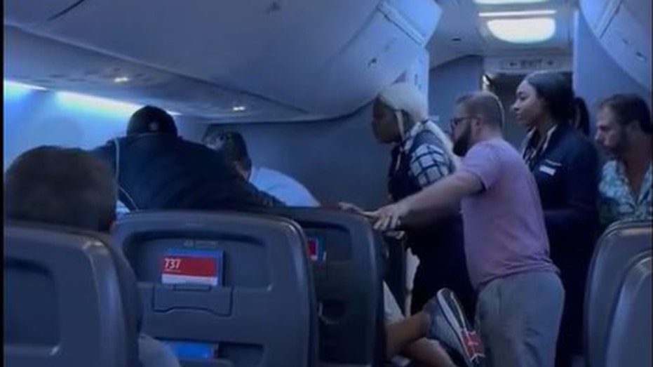 Passengers intervene on flight when man allegedly attacks woman next to him, video shows thumbnail