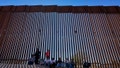 FILE - A group claiming to be from India sit in the shade of the border wall as they wait to be picked up by Border Patrol after crossing through the border fence in the Tucson Sector of the U.S.-Mexico border, Aug. 29, 2023, in Organ Pipe Cactus National Monument near Lukeville, Ariz. (AP Photo/Matt York, File) - Fox News