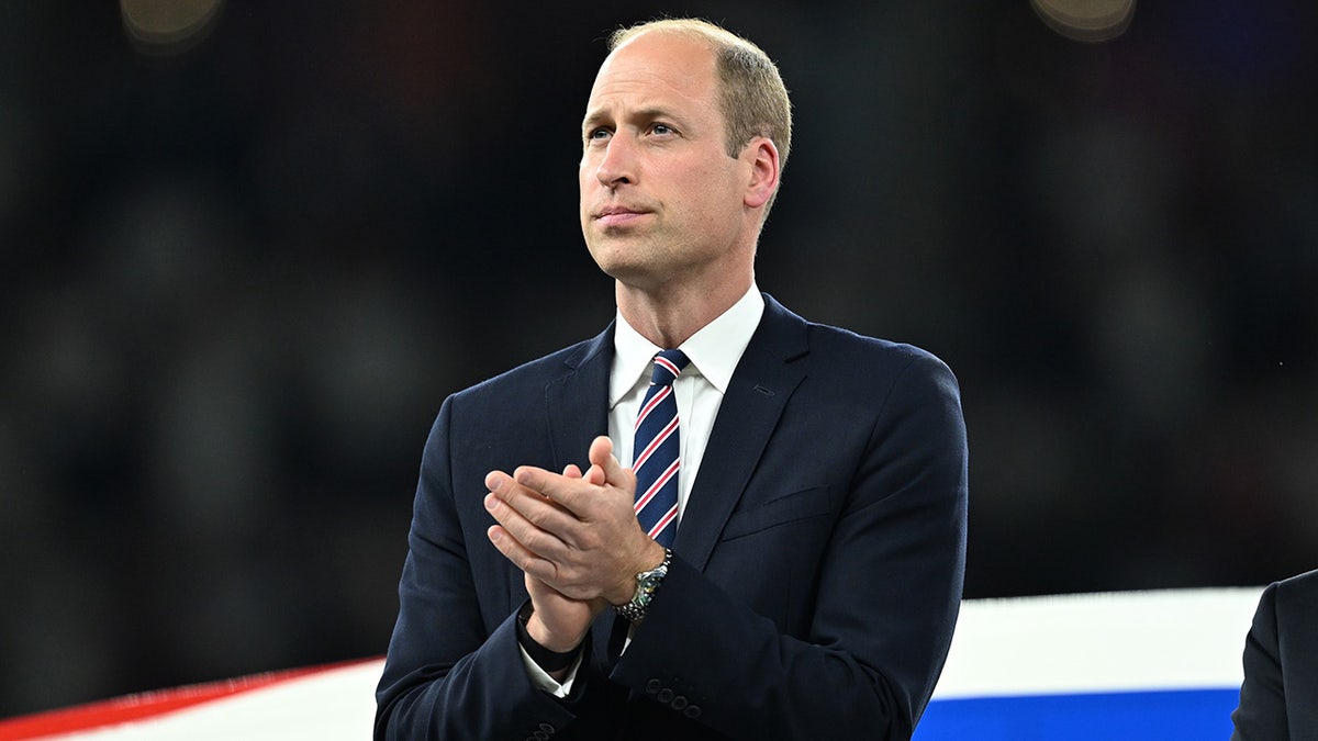 A close-up of Prince William applauding.