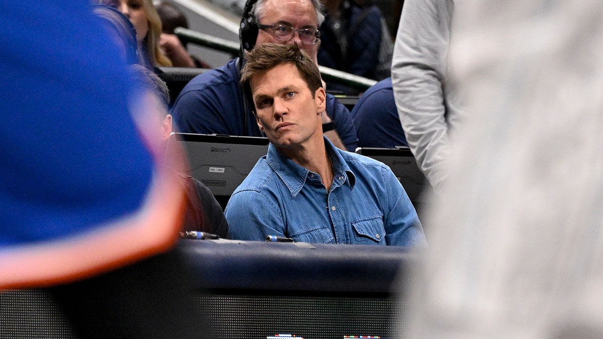 Tom Brady looks on the NBA court