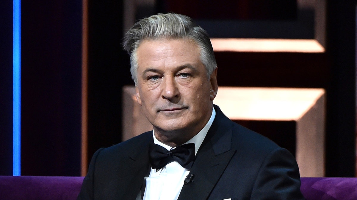 Actor Alec Baldwin wears a tie and a black suit.