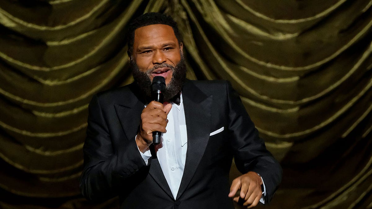 Anthony Anderson hablando en el escenario vestido de esmoquin