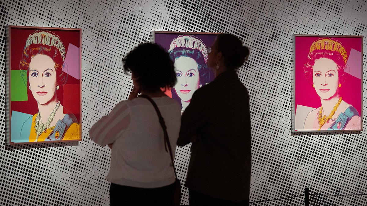 La gente mira el retrato de la reina Isabel II Warhol