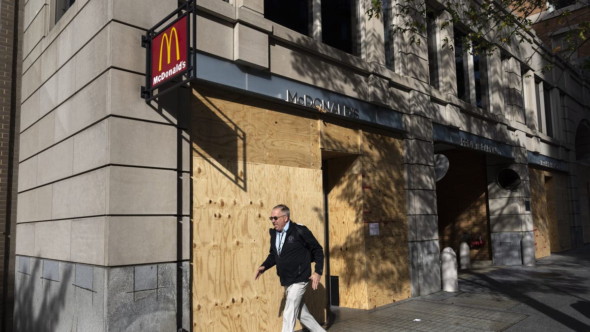 Man walks past boarded-up McDonald's in Washington, DC 