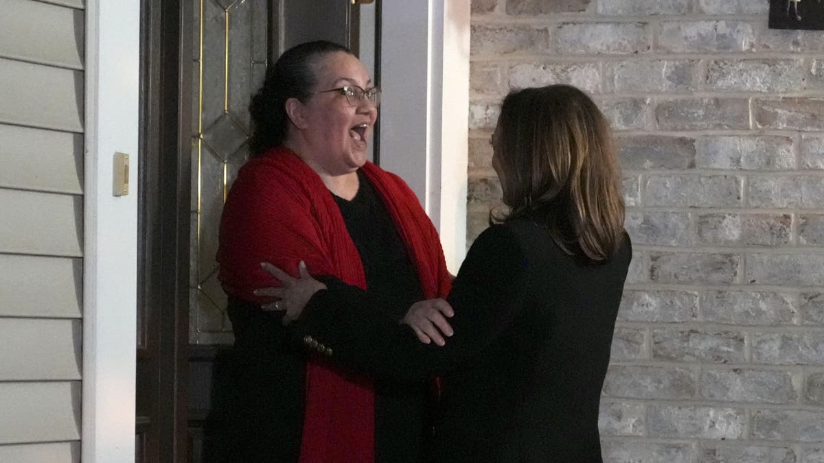 Harris hugs a woman as she knocks on a door in Pennsylvania