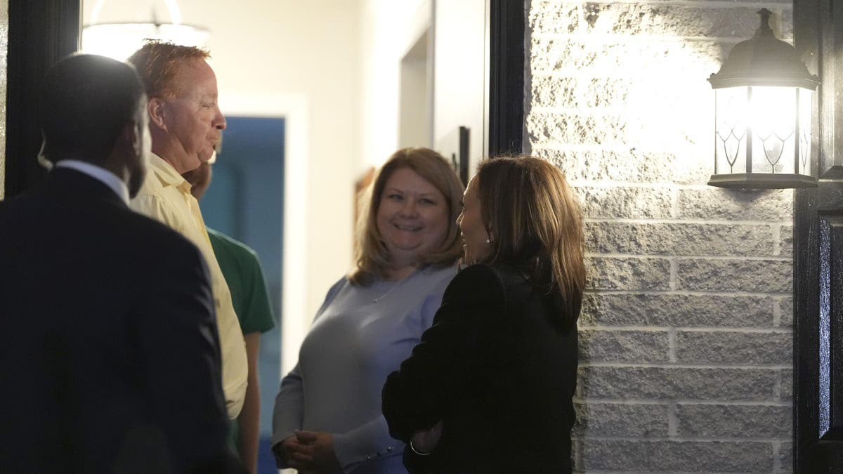 Harris speaks to the couple during the staged door knocking