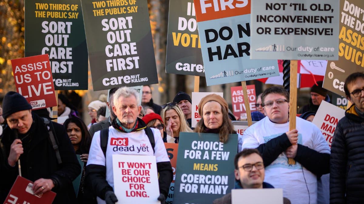 opponents to a measure  to legalize assisted dying holding signs