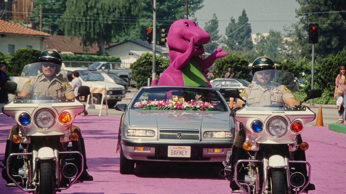 barney el dinosaurio montado en una caravana