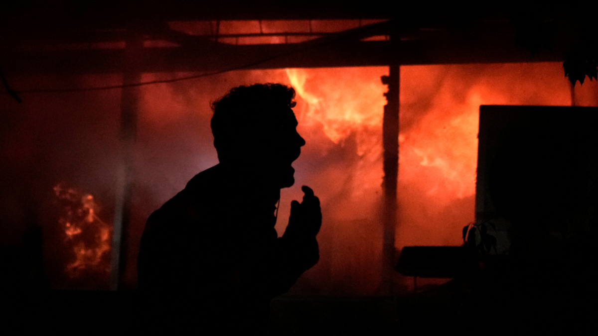 A man screams in front of a fire erupting inside a computer shop hit during an Israeli airstrike in central Beirut on Nov. 17, 2024.