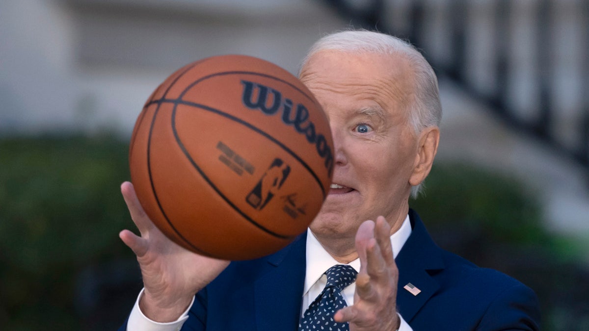 President Joe Biden throws a basketball he received from the Boston Celtics at an event to celebrate the team's victory in the 2024 NBA championship, on the South Lawn of the White House in Washington, D.C., Thursday.