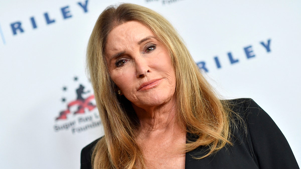 Caitlyn Jenner looks serious in black, staring at the camera on the carpet