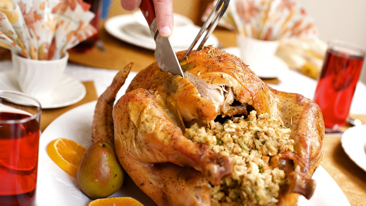 A turkey with stuffing is being carved.