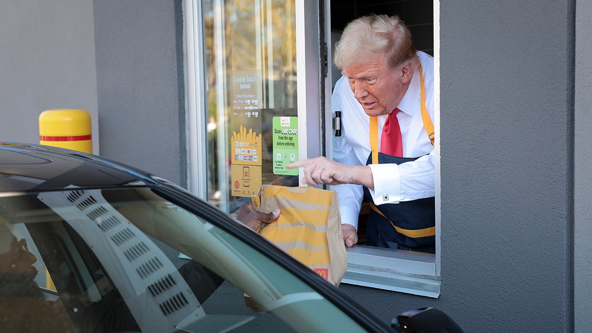 Republican presidential candidate and former president Donald Trump works at a drive-thru line during an election campaign while visiting a McDonald's restaurant.