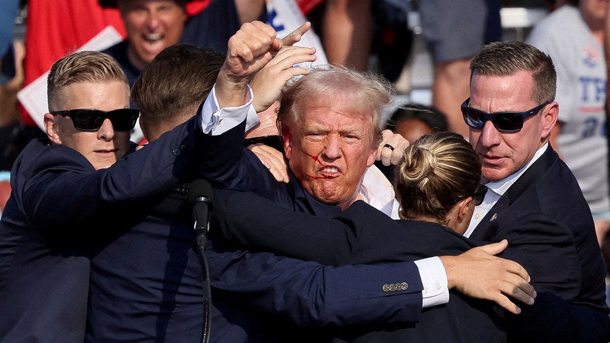 Republican presidential candidate and former President Donald Trump is assisted by the Secret Service after gunfire rang out during a campaign rally