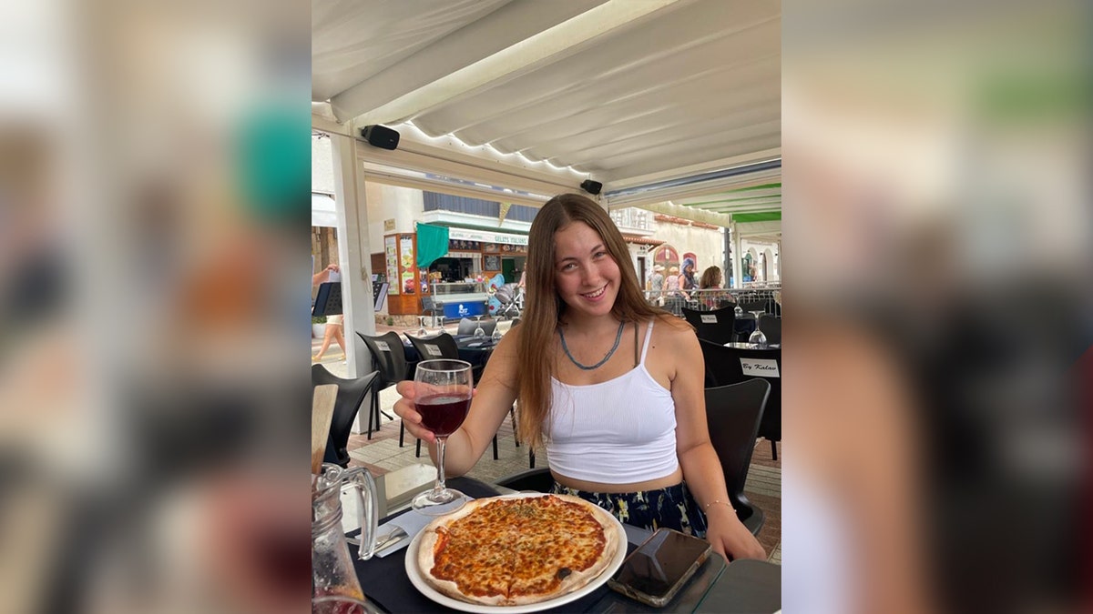 portrait of woman with pizza at a restaurant