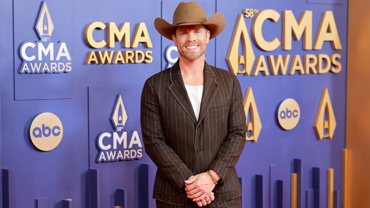 Dustin Lynch wore a brown suit and cowboy hat to the CMA Awards red carpet.