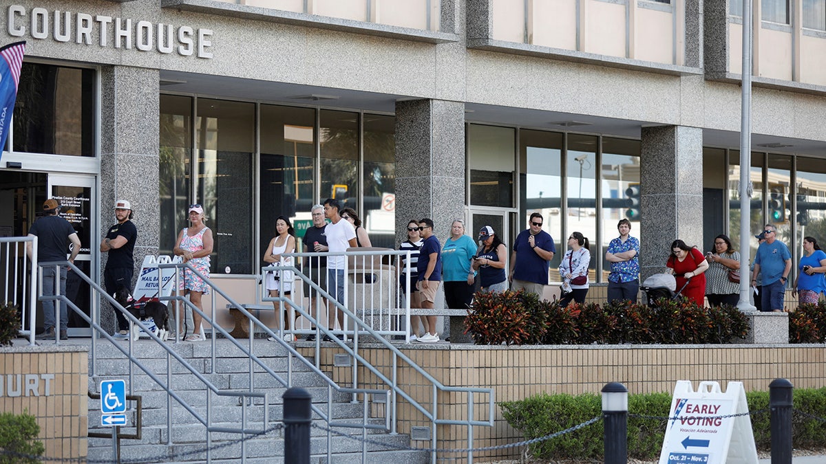 Florida residents wait in line at an early polling place to cast their votes in local, state and national elections in Clearwater, Florida