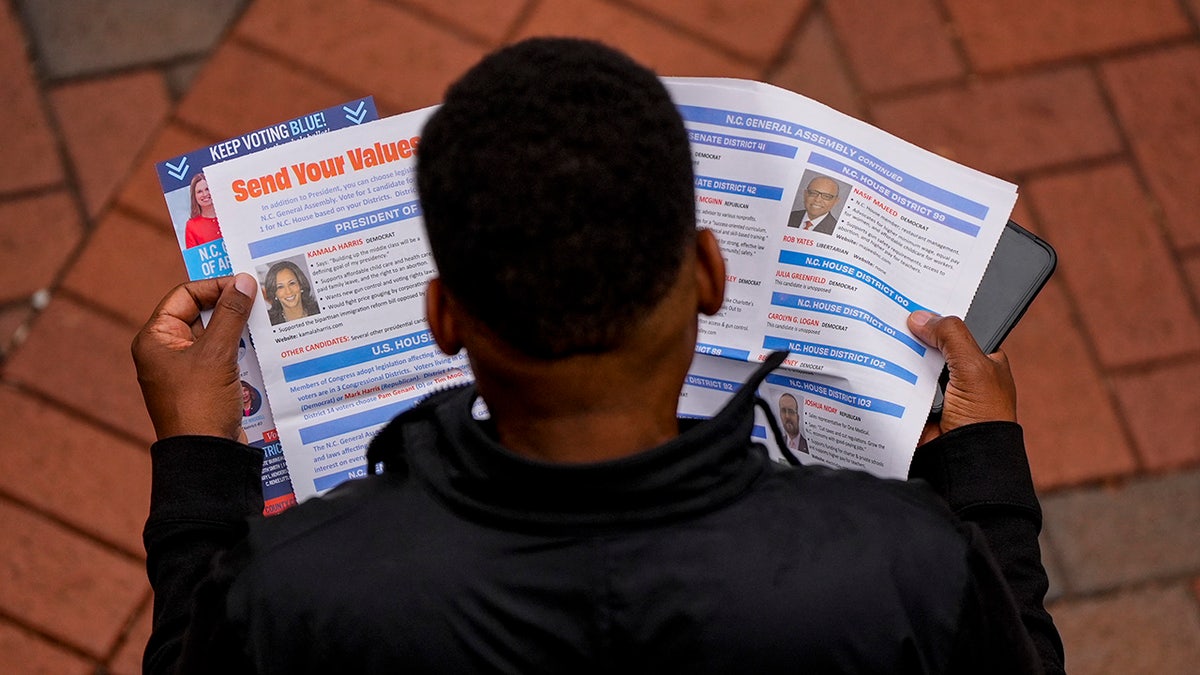 A man reads election materials before voting on the last day of early voting