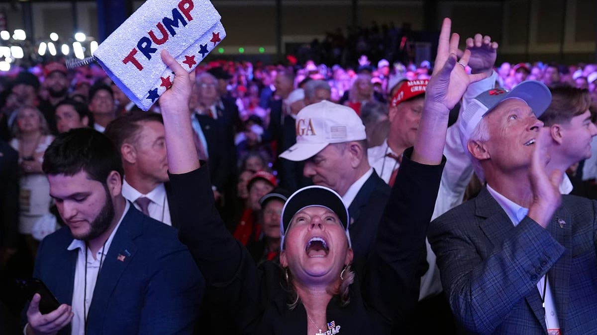 A woman reaches for the sky after it becomes clear that Trump wins the 2024 general election