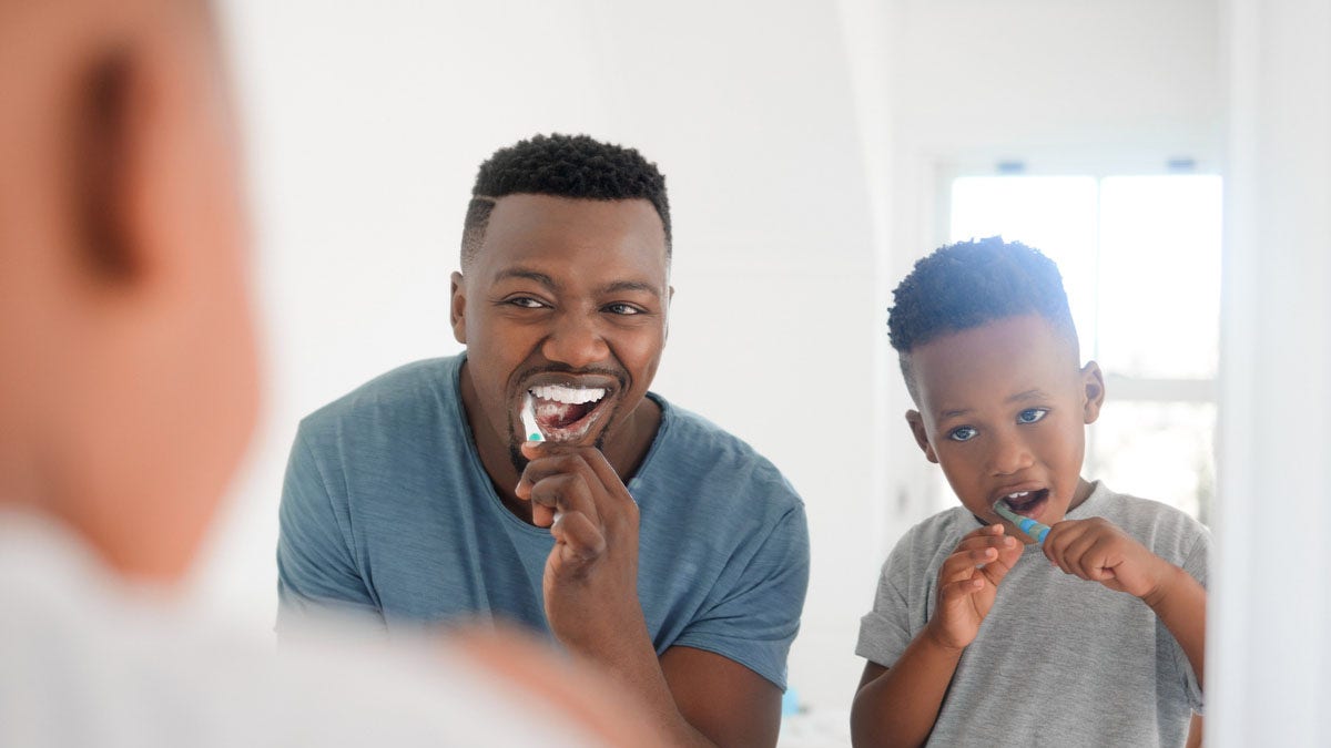 Father son brushing teeth