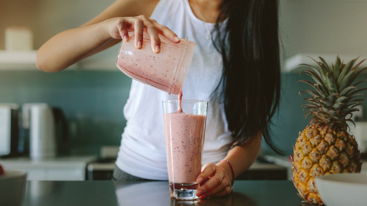 Woman pouring a fruit smoothie