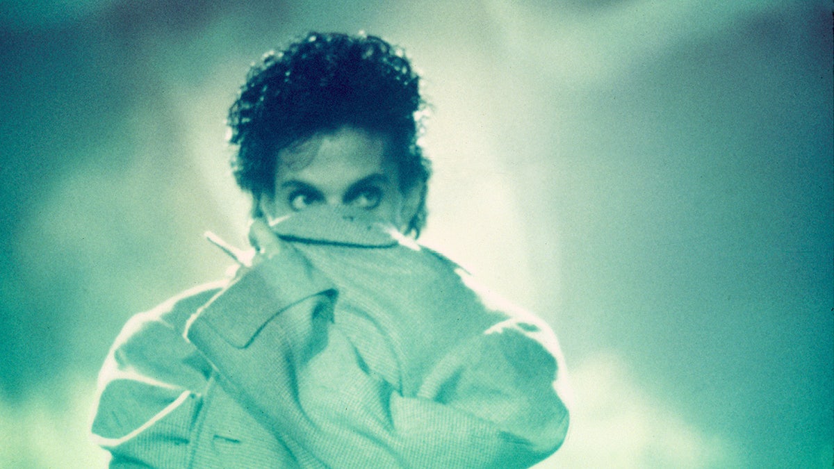 Prince made deliberate move to escape temptations of fame: pal Prince hiding his face.