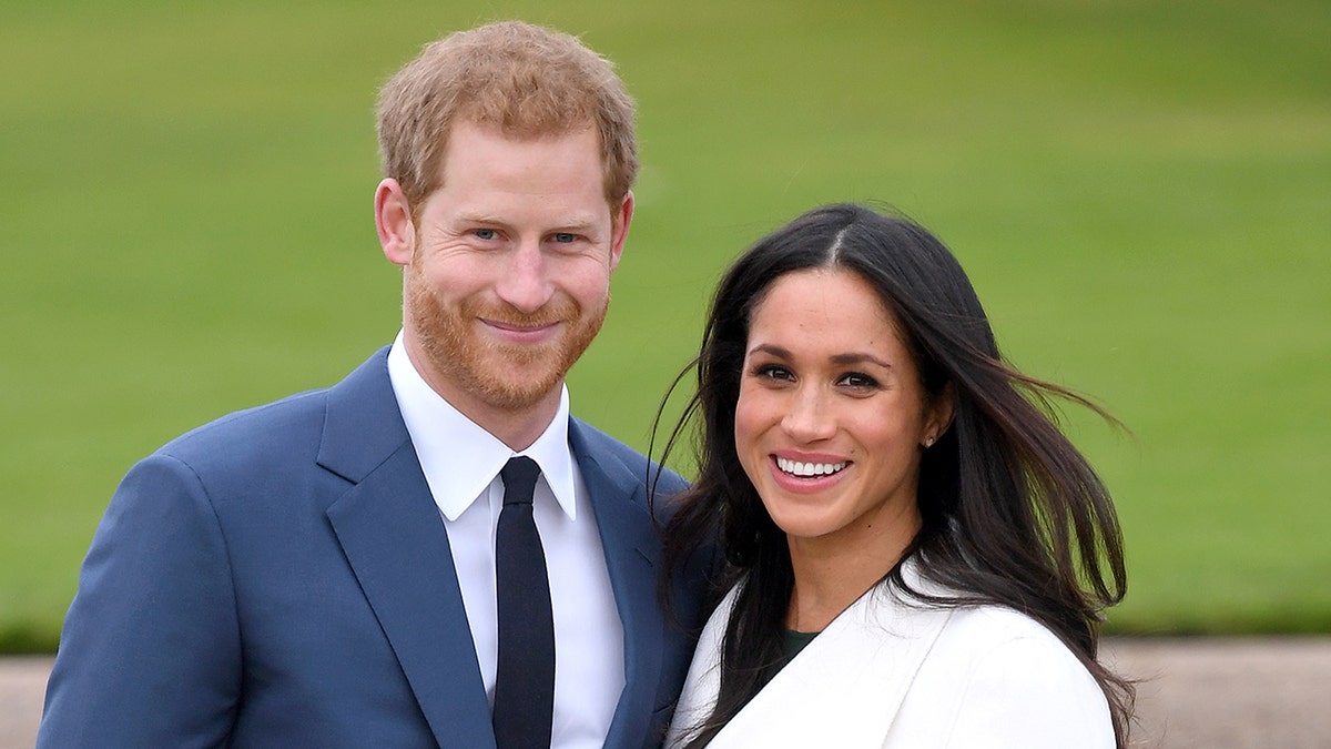 A close-up of Prince Harry and Meghan Markle smiling outdoors.