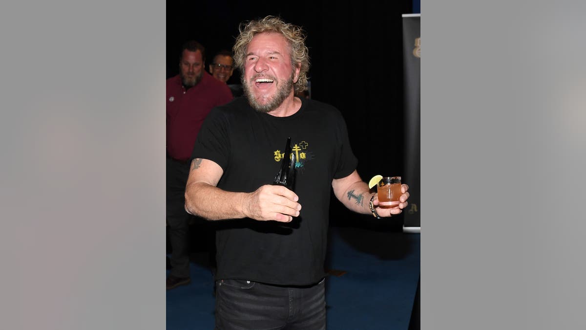 sammy hagar holding a glass of santos