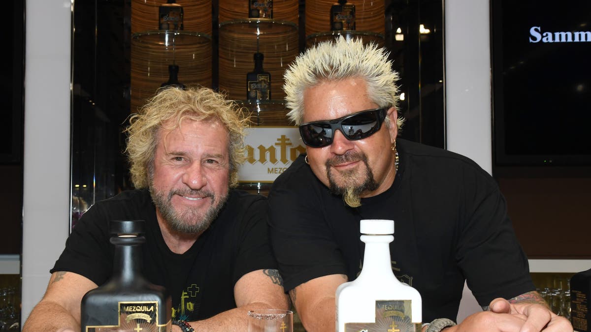 guy fieri and sammy hagar pose with santos bottles