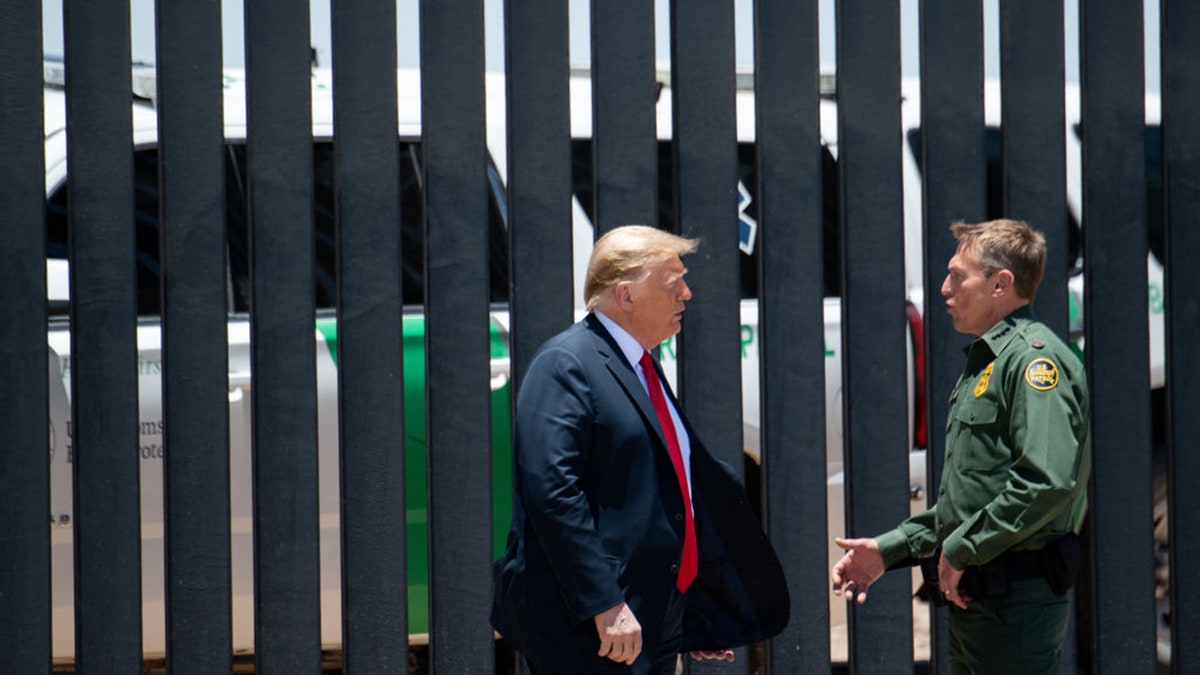 US President Donald Trump speaks with US Border Patrol Chief Rodney Scott (R) as they participates in a ceremony commemorating the 200th mile of border wall at the international border with Mexico in San Luis, Arizona, June 23, 2020. (Photo by SAUL LOEB / AFP) (Photo by SAUL LOEB/AFP via Getty Images)