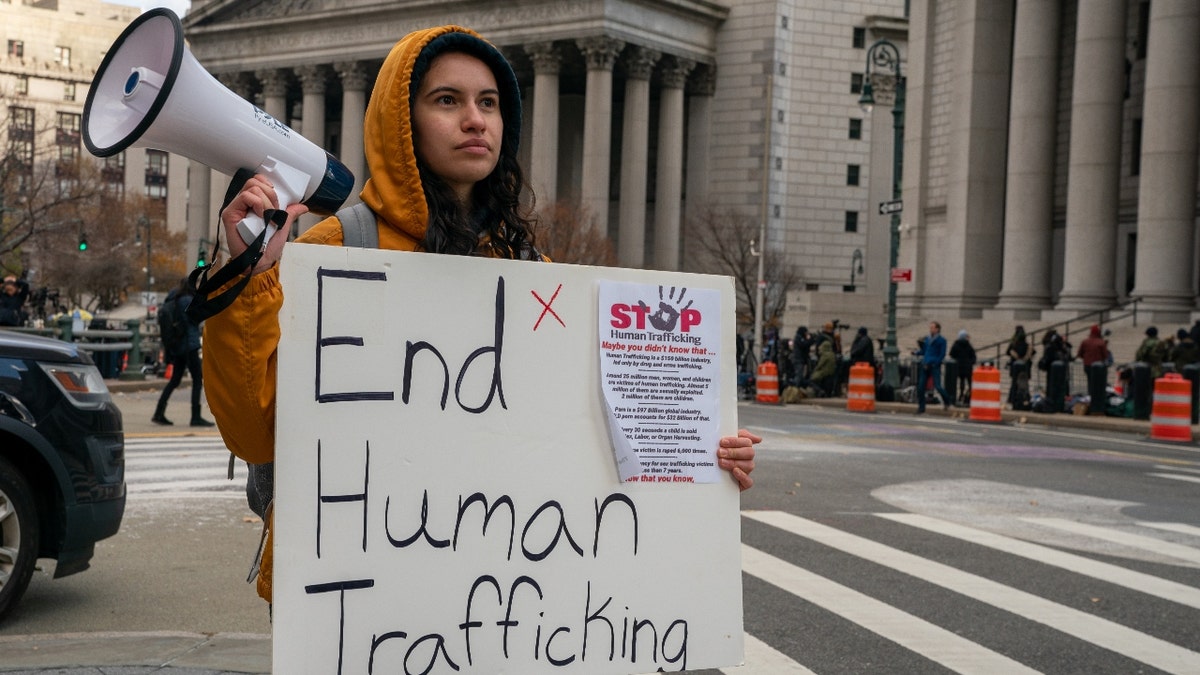 People gather to protest human trafficking at the Thurgood Marshall United States Courthouse where the trial of Ghislaine Maxwell is being held on November 29, 2021 in New York City.