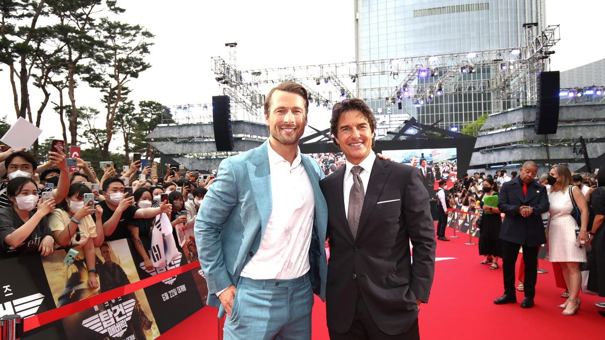 glen powell and tom cruise on red carpet 