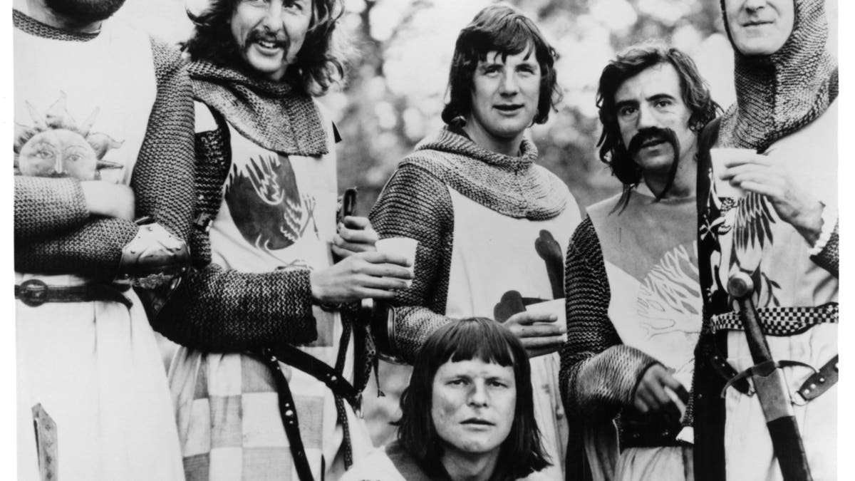 Graham Chapman, Eric Idle, Terry Gilliam, Michael Palin, Terry Jones, and John Cleese standing together in a scene from the film 'Monty Python And The Holy Grail', 1975. (Photo by EMI Films/Getty Images)