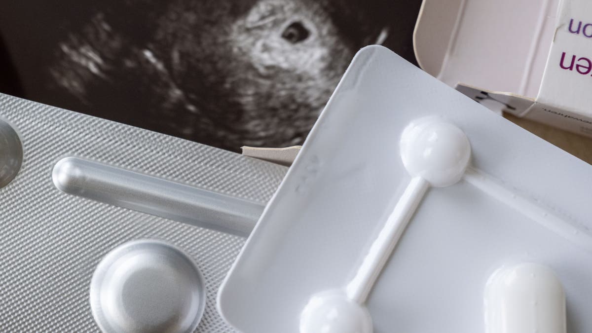 Medication to terminate a pregnancy can be seen in a gynecologist's office in front of an ultrasound image.