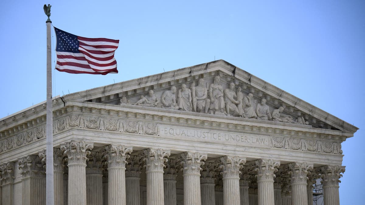 US flag waving in front of the Supreme Court building in DC