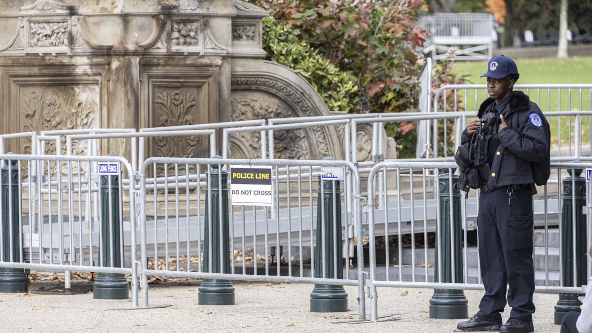 Un agente de policía del Capitolio cerca de la valla de seguridad antes de la jornada electoral 