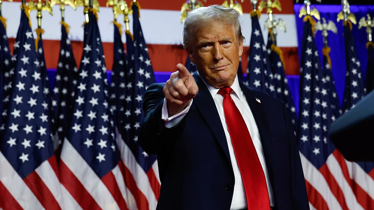 Donald Trump in red tie, pointing