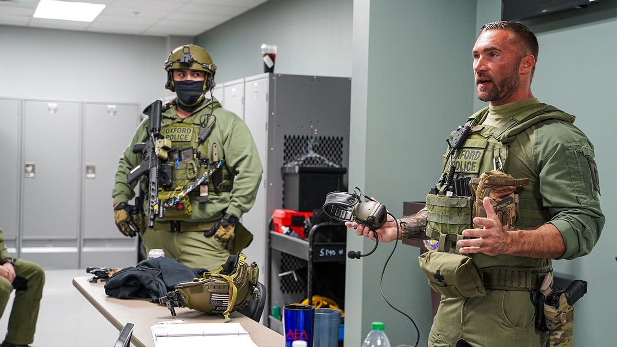 Policía de uniforme preparándose para ejecutar una orden de registro.