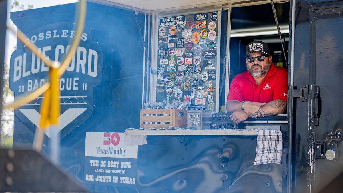 steven rossler in the window of his bbq trailer