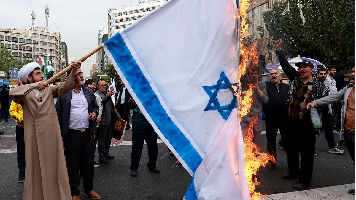 Manifestantes iraníes queman la bandera israelí