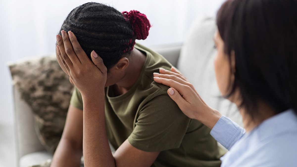 Psychotherapist consoling and supporting female soldier with ptsd