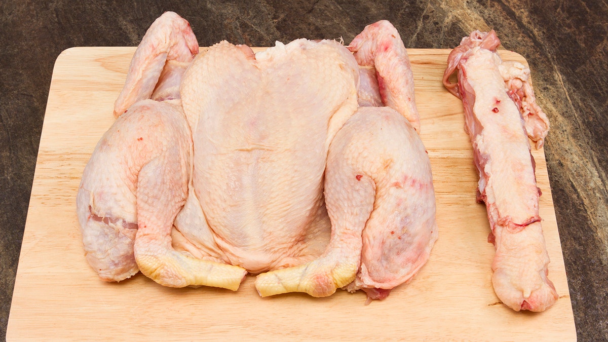 A spatchcocked chickenhearted  connected  a woody  cutting board.