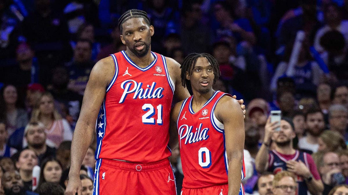 Joel Embiid stands with Tyrese Maxey