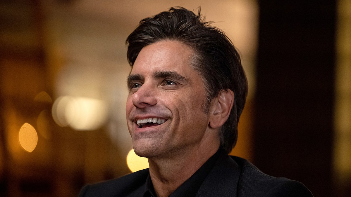 John Stamos looks up in a side profile shot of his face and dark hair