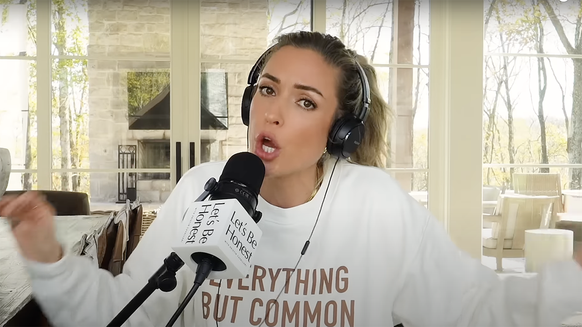 Kristin Cavallari wears a sweatshirt and large  achromatic  earphones portion    she animatedly speaks into her podcast microphone 