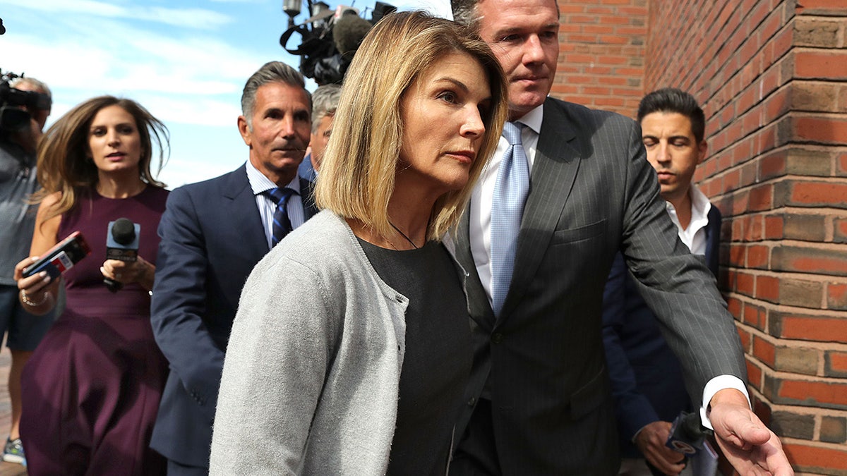 Lori Loughlin and her husband Mossimo Giannulli walking into court