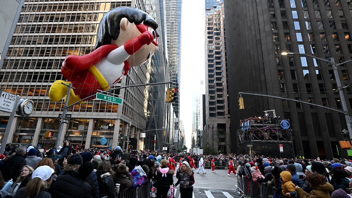 96th Macys Thanksgiving Day Parade in New York, balloon crosses intersection with large crowd looking up