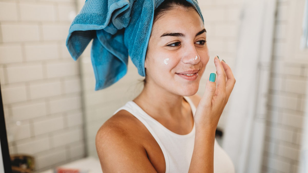 A woman is doing her skin care routine.