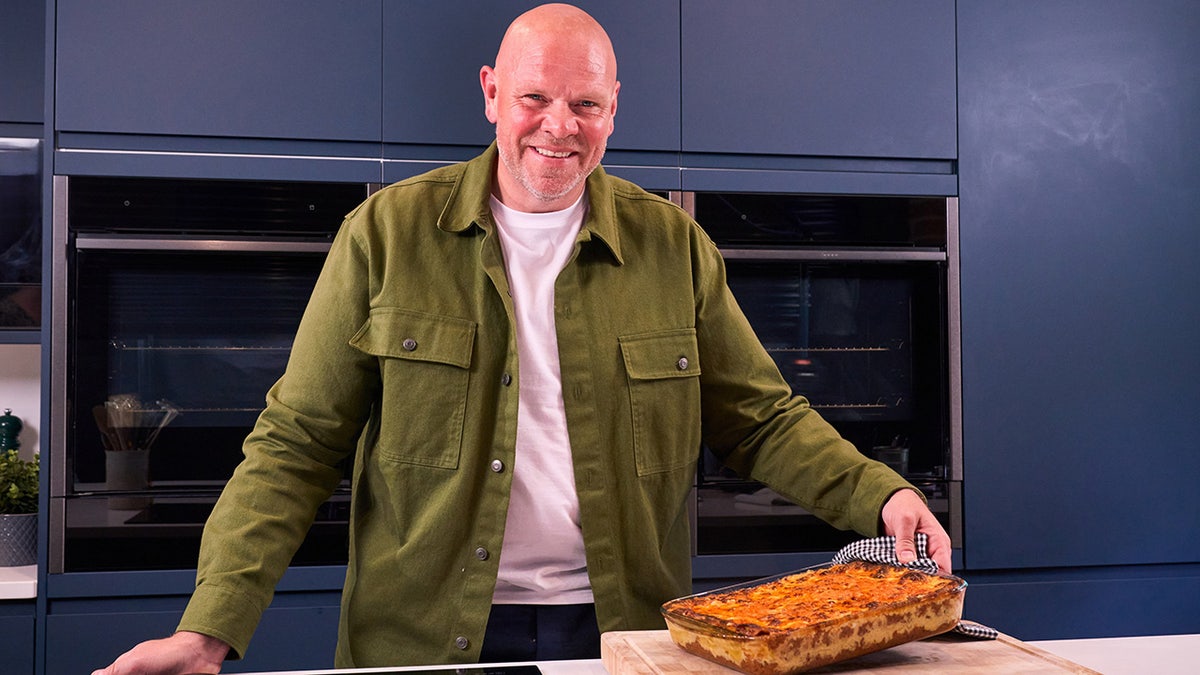 Man posing with a dish of pasta.